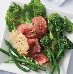 Green beans, sliced steak, broccolini , and parmesan chip on a white square plate