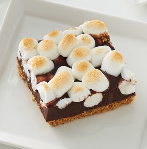 White plate with a toffee bar, topped with golden-brown mini marshmallows