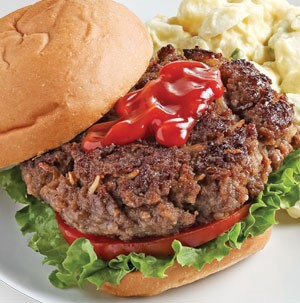 Burger with ketchup, lettuce and tomato sandwiched between a bun