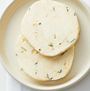 Circular slices of compound butter on a white dish