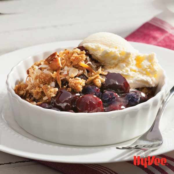 Bowl of cherry cobbler topped with a scoop of vanilla frozen yogurt