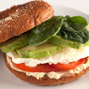 Multi-grain bagel topped with spreadable cheese, tomato, egg white, avocado and spinach