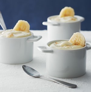 Small casserole dishes filled with banana pudding and garnished with fresh banana slice