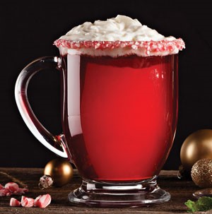Glass mug filled with red poinsettia drink with whipped topping for garnish