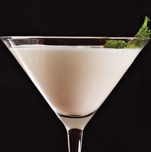 White martini in glass garnished with fresh mint leaves