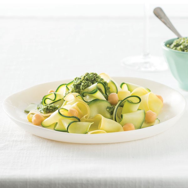 Ribbons of zucchini noodles topped with garbanzo beans and pesto