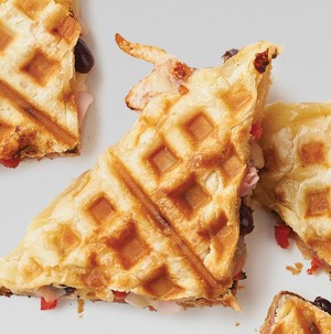 Waffle panini filled with black beans, pepper, cheese, and sliced deli meat