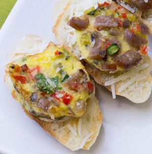 Toasted bread topped with slice of frittata with mixed vegetables and egg
