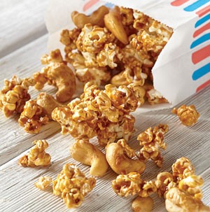 Paper bag filled with salted caramel cashew popcorn