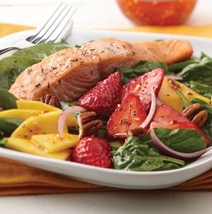 Bed of spinach topped with salmon, strawberries, onions and mangos