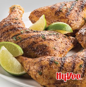 Seasoned and grilled chicken leg quarters served with lime wedges