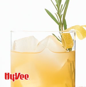 Tea topped with ice cubes, lemon peel, and fresh rosemary sprig