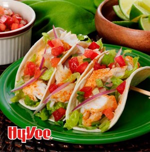 Seasoned white fish in flour tortillas with diced tomatoes, shredded lettuce and sliced red onions