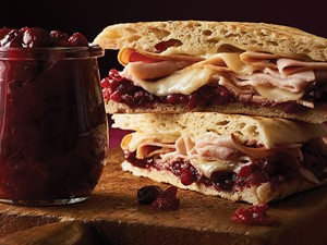 Artisan bread topped with cranberry sauce, cheese, and sliced turkey