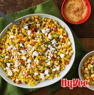 White bowl filled with corn and topped with crumbled white cheese