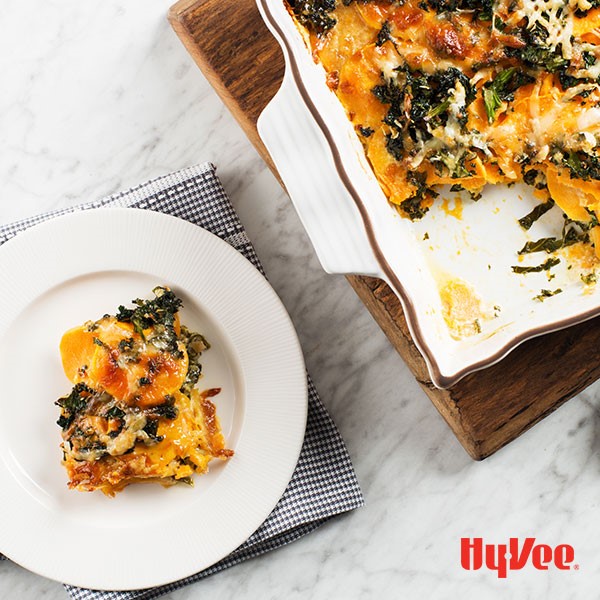 Potato and Kale gratin baked in a casserole dish with piece on a plate