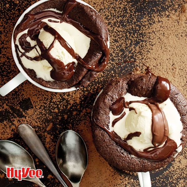 Mug filled with brownie and topped with vanilla ice cream and chocolate syrup