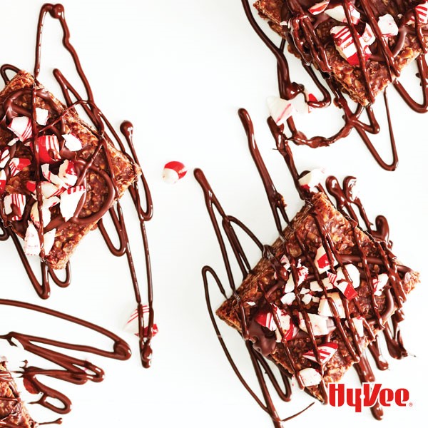Chocolate oatmeal bars topped with crushed peppermint candies and drizzled with melted chocolate