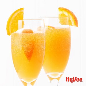 Carbonated orange beverages with orange slices in the drink and on the glass