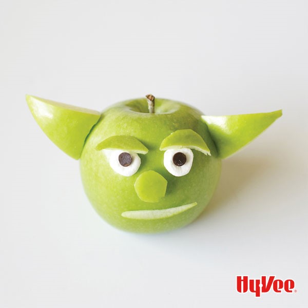 Green apple with cut apples for ears, eyebrows nose and mouth with marshmallow and mini chocolate chip eyes