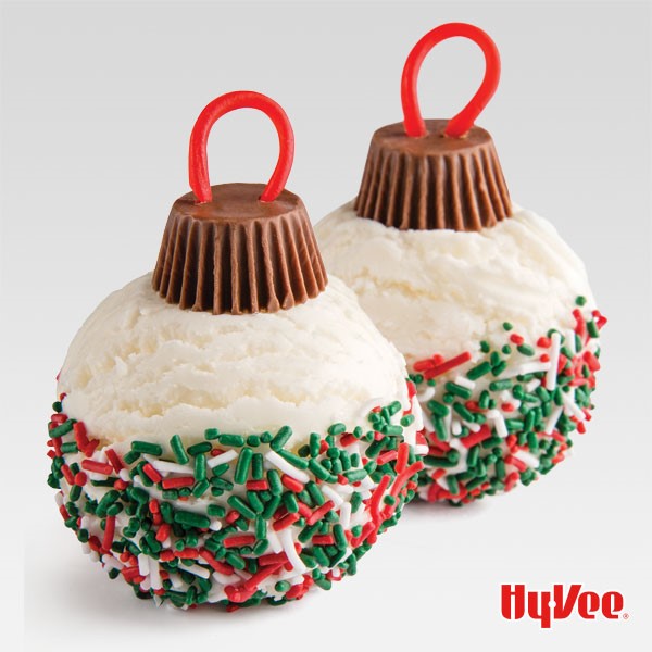 Ice Cream balls dipped in green, white and red jimmies topped with a mini peanut butter cup and a red licorice string