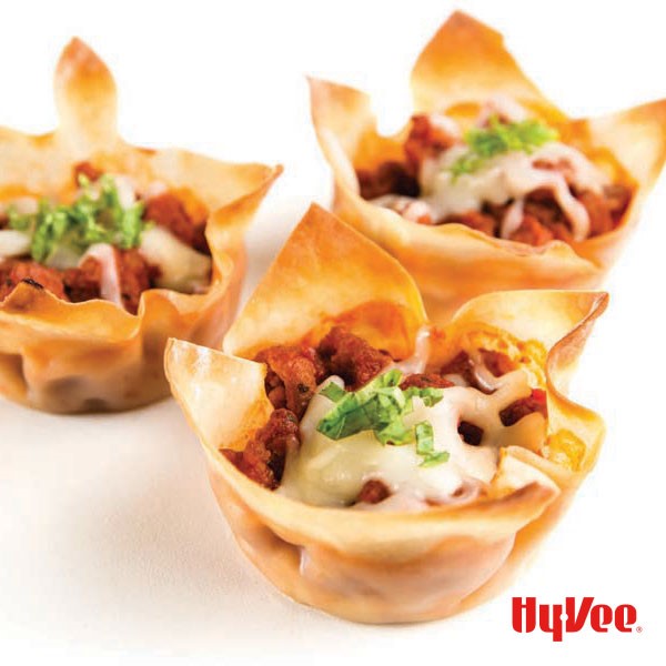 Phyllo dough cups filled with ground meat, cheese, and topped with fresh herbs.
