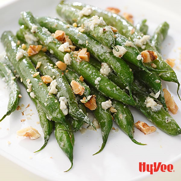 Platter of green beans topped with blue cheese and chopped walnuts
