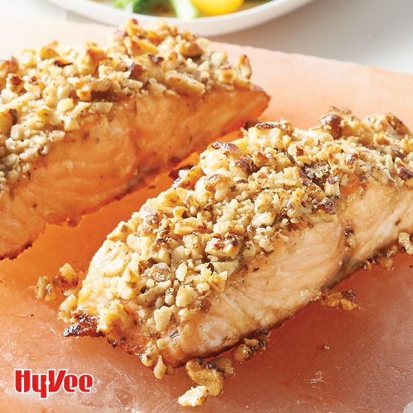 Cooked salmon crusted with nuts on pink Himalayan salt block