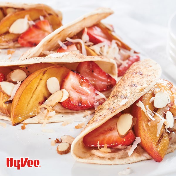 Cinnamon seasoned tortillas filled with grilled strawberries and peaches and topped with toasted coconut and sliced almonds