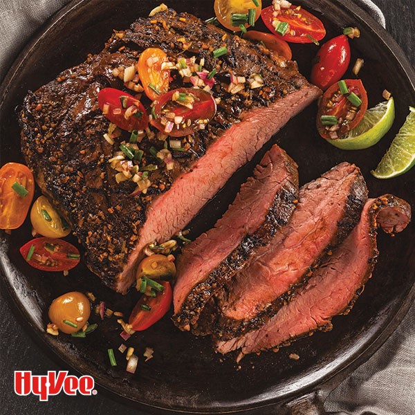 Cast iron filled with seared flank steak and grape tomatoes