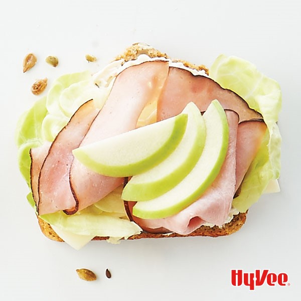 10-grain bread slice topped with onion dip, lettuce, ham and green apple slices