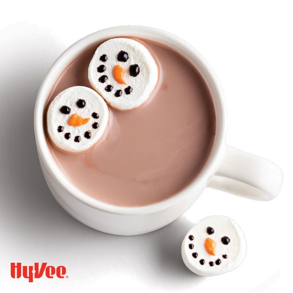 Mug of hot chocolate served with snowman-decorated marshmallows using chocolate and orange melts