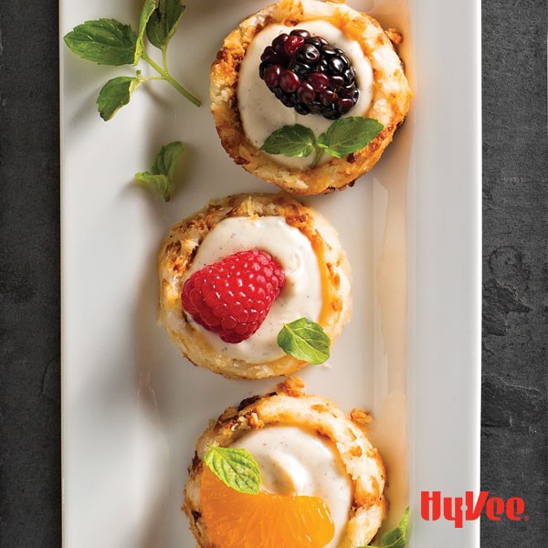 Platter of macaroons filled with vanilla creme fraiche and garnished with fruit and mint leaves