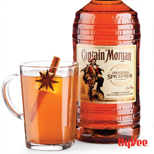 Glass of Captain Morgan spiced cider garnished with star anise, apple wedge and cinnamon stick