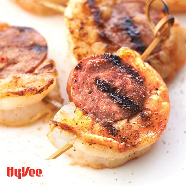 Wooden skewers of grilled andouille sausage and shrimp