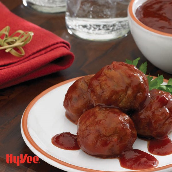 Meatballs covered in sauce and garnished with fresh parsley