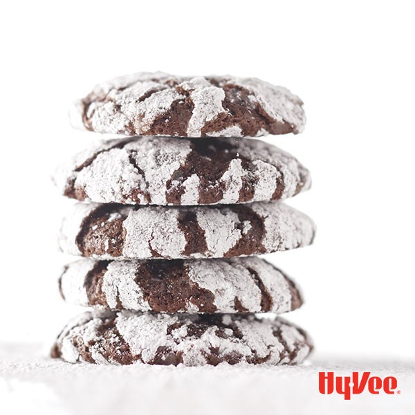 Stacked chocolate crinkle cookies covered in powdered sugar