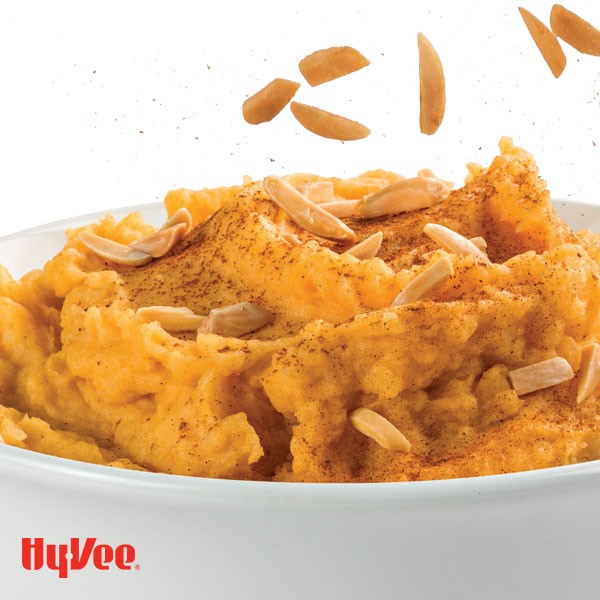 Bowl of mashed sweet potatoes, garnished with almonds and cinnamon 
