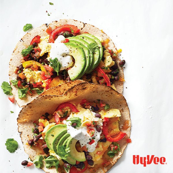 Whole wheat soft-shell tortillas filled with scrambled egg, pico de gallo, black beans, cilantro, bell peppers, cheese, avocado and a dollop of greek yogurt