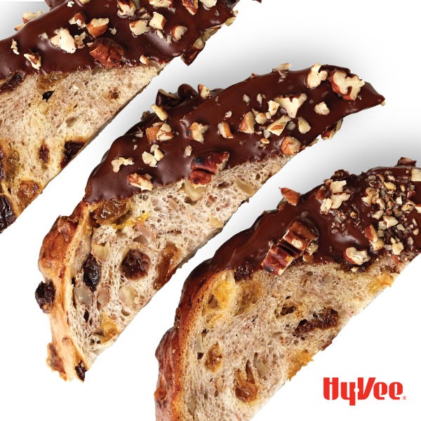 Biscotti slices half dipped in chocolate and garnished with chopped pecans