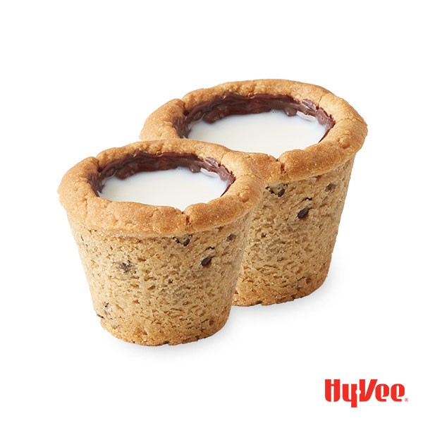 Chocolate chip cookie in muffin cups with hole in middle coated with melted chocolate and filled with milk