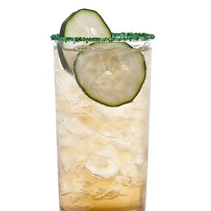 Green sugar-rimmed glass of gold liquid, garnished with cucumber slices