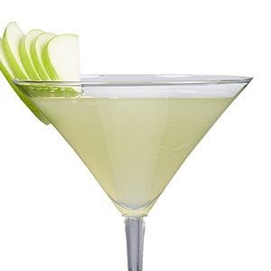 Martini glass filled with shamrock shaker, garnished with green apple slices