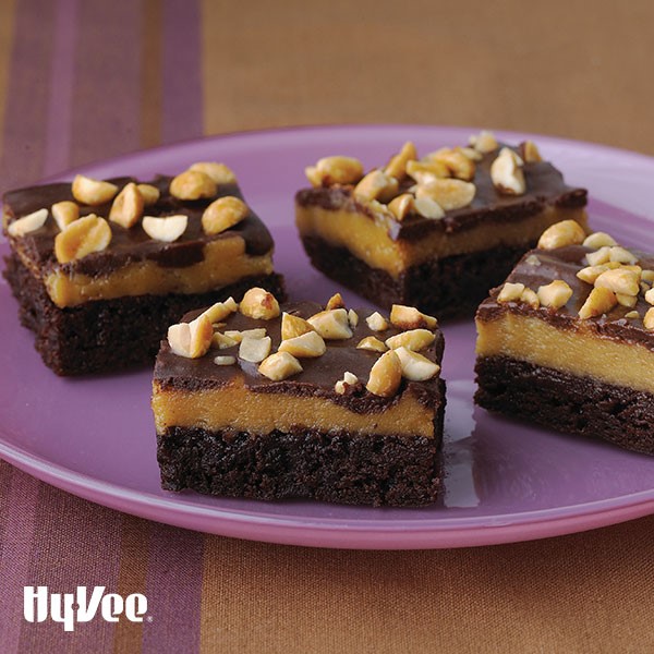 Brownie crust topped with peanut butter and chocolate glaze and garnished with chopped peanuts