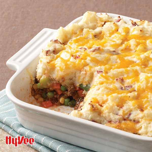 Casserole dish filled with beef and vegetables and topped with cheesy mashed potatoes