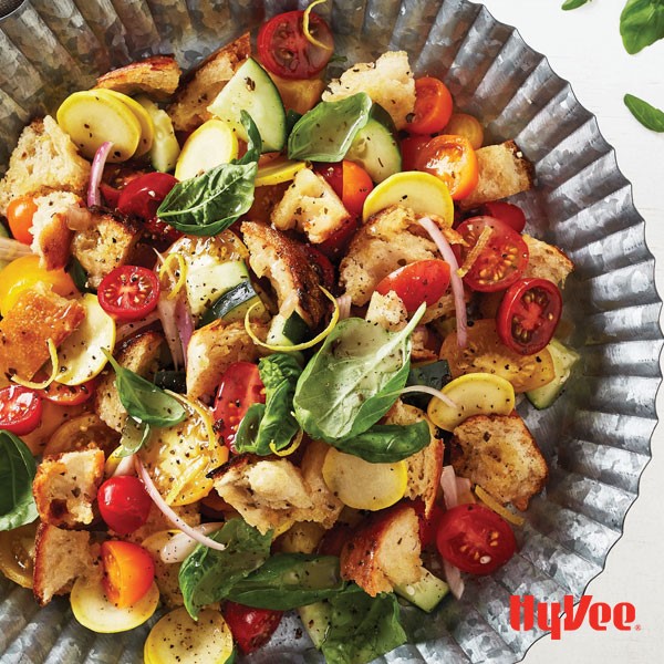 Bowl of toasted bread cubes mixed with vegetables and vinaigrette