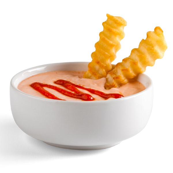 Two crinkle-cut french fries dipped into a cup of sriracha dip