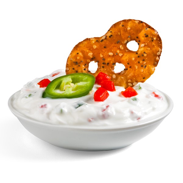 Cracker dipped into cup of spicy pepper dip and garnished with a sliced jalapeno and pimento peppers