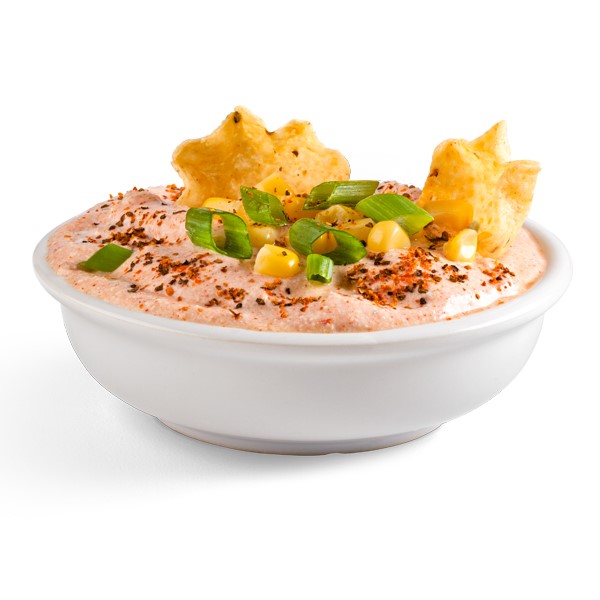 White bowl filled with orange dip and topped with chopped green onions, corn kernels, and tortilla chips