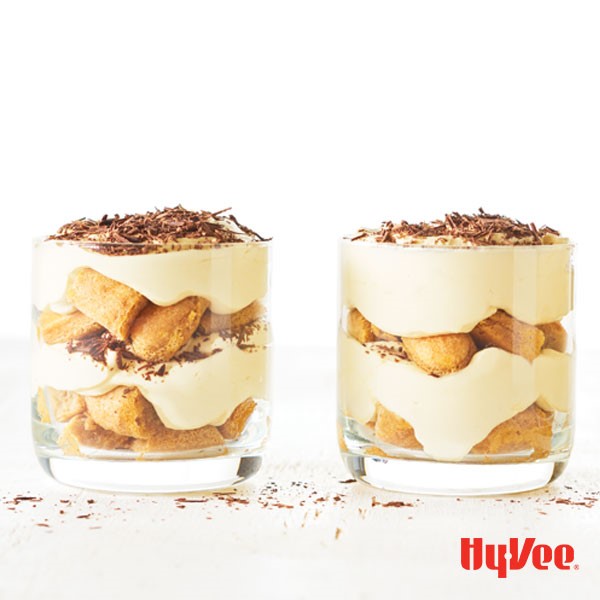Glasses layered with lady fingers, custard, and topped with chocolate shavings